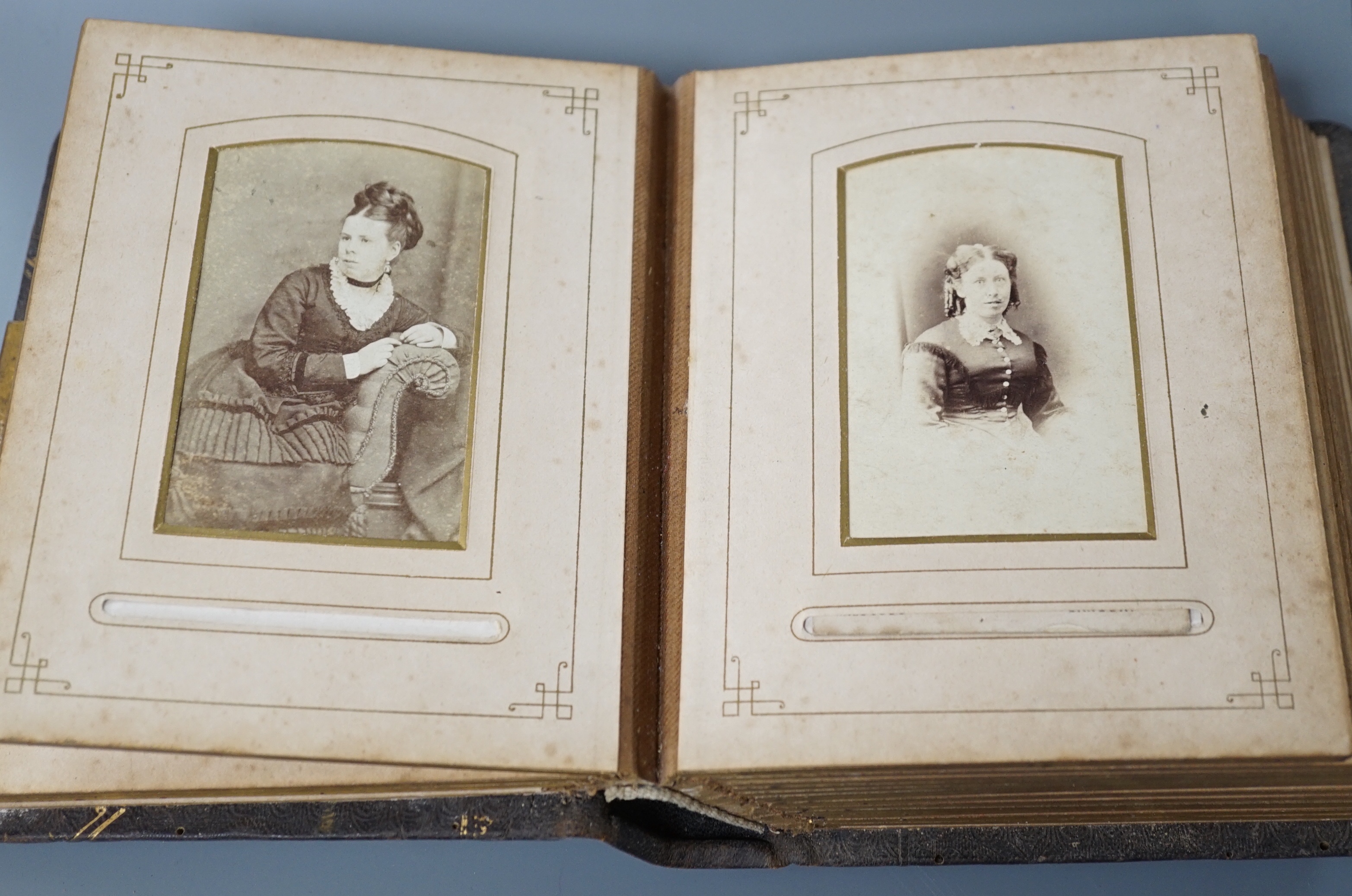 A Victorian portrait photograph album in clasp bound book containing cabinet cards